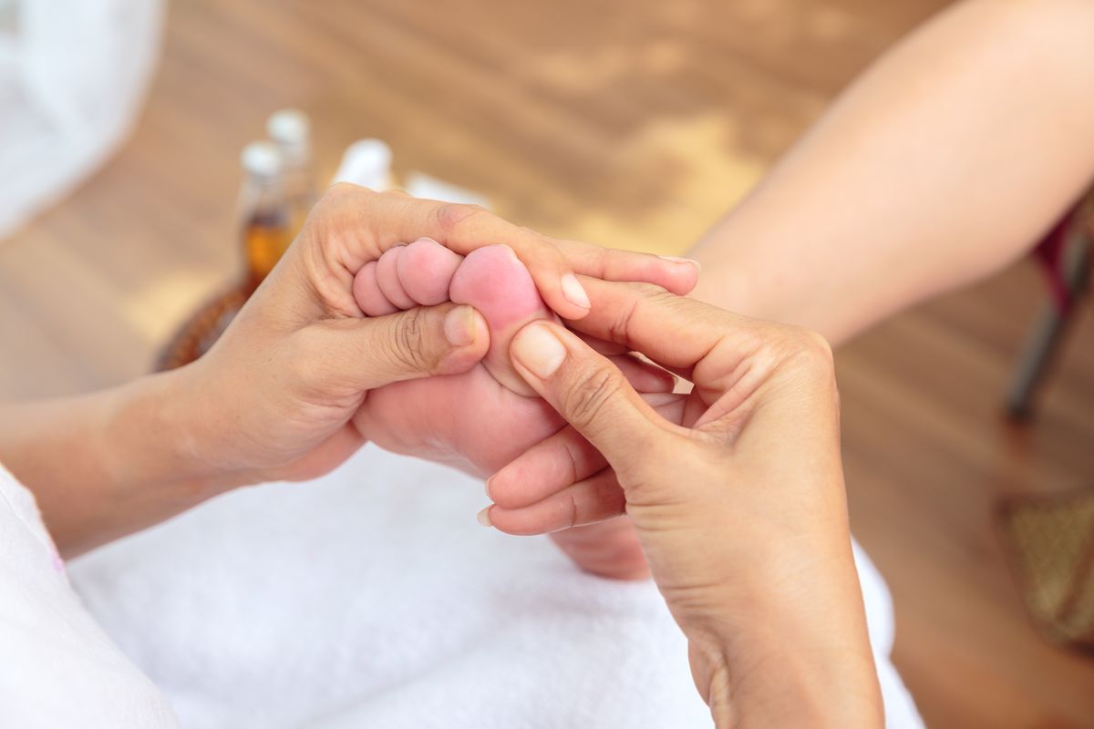 Handen masseren een voetzool tijdens een ontspannende voetmassage